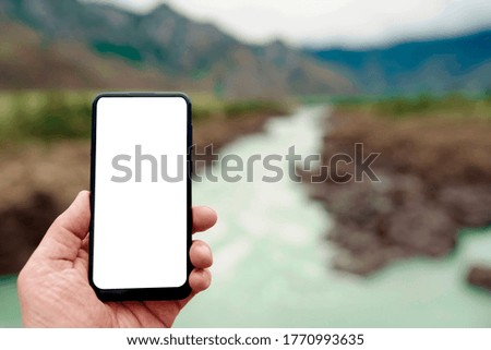 Blank screen digital smart phone in hand the explorer and traveler in the mountains. 