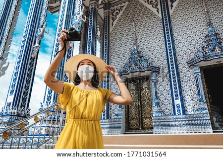 New normal travel concept, Happy traveler asian woman with mask and camera sightseeing in Wat Pak Nam Khaem Nu temple, Chanthaburi, Thailand Royalty-Free Stock Photo #1771031564