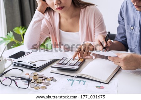 Stressed young couple calculating monthly home expenses, taxes, bank account balance and credit card bills payment, Income is not enough for expenses.