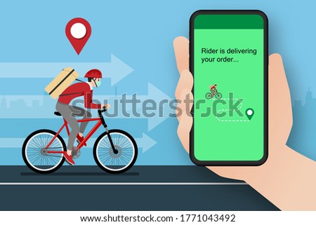 A delivery man who get an order from smart phone, delivering a parcel to customer by bicycle and the city in the background. Stay safe at home delivery during coronavirus covid-19 crisis concept. 