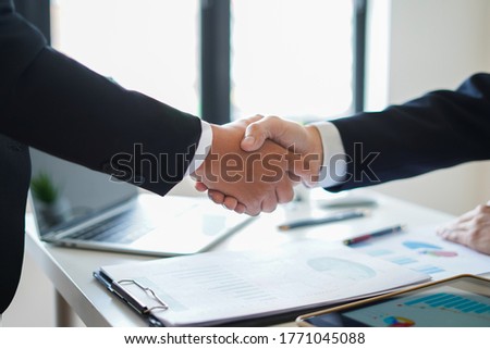 Businessman partner shaking hand to congratulate after agreement and deal their business to expand  investment success and company profit increase