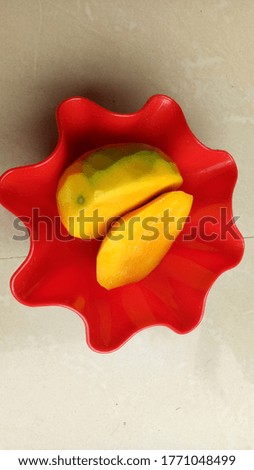 Close up of mango sliced in a red color plate