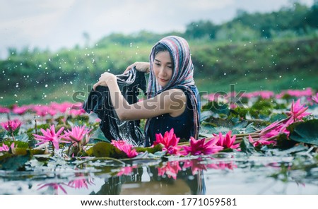 Beautiful women  holding  cloth  high and low  in beautiful lotus lake