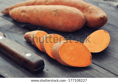Raw sweet potatoes on wooden background closeup Royalty-Free Stock Photo #177108227