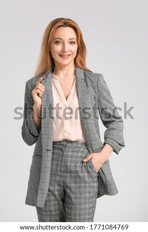 Portrait of stylish businesswoman on light background