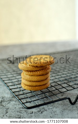 A row of biscuits with coconut chips on a cooling rack