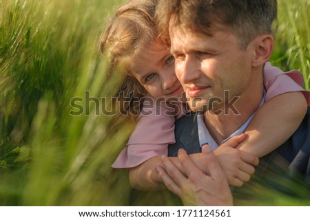 Father and daughter in a green wheat field. close-up. Focus on the girl.