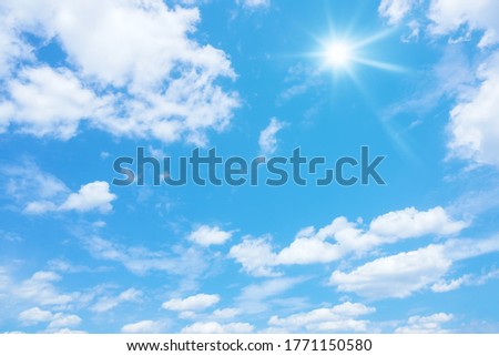 An image of a blue sky with sun and clouds background