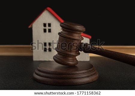 Judges hammer on background of model house. Settle house dealing lawsuit. Confiscated housing. concept of resolving property disputes Royalty-Free Stock Photo #1771158362