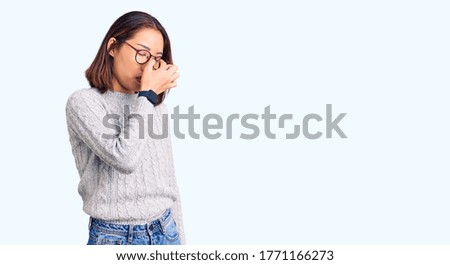 Young beautiful chinese girl wearing casual clothes tired rubbing nose and eyes feeling fatigue and headache. stress and frustration concept. 