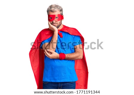 Young blond man wearing super hero custome thinking looking tired and bored with depression problems with crossed arms. 