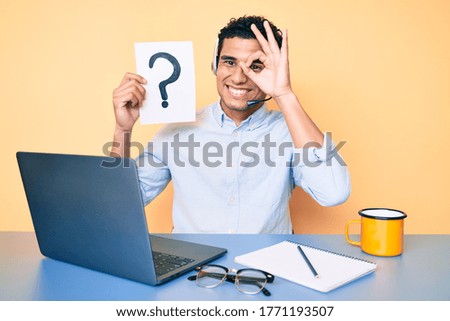Young handsome hispanic man holding question mark as customer support smiling happy doing ok sign with hand on eye looking through fingers 