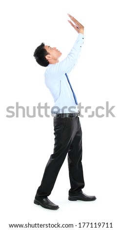 Full length of businessman posing for conceptual photo. pushing something up