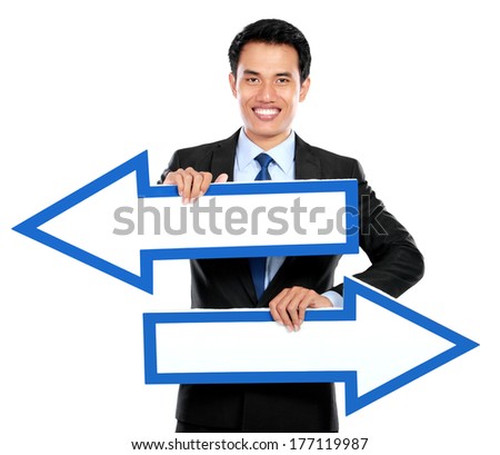 Businessman holding arrow pointing right and left in hand on white background