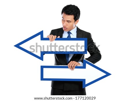 Businessman holding arrow pointing right and left in hand on white background