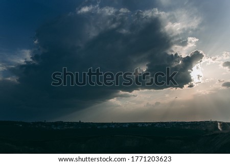 Beautiful dark sky with sun rays. Sunset, three-dimensional large storm clouds.