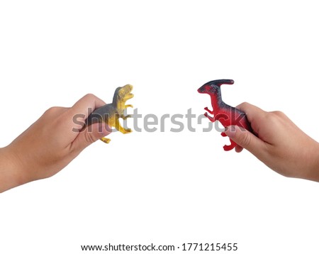 Isolated on a white background of Asian woman's hands holding red and yellow dinosaurs to play to fight for fun.