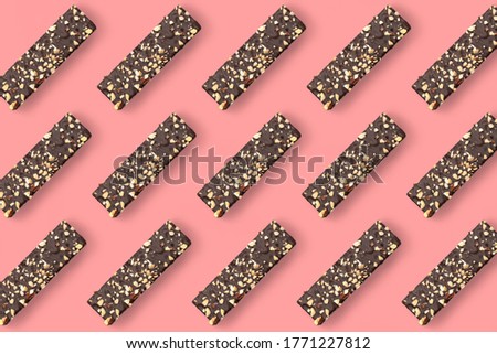 pattern of chokolate waffel with nut sprinkling on the background.