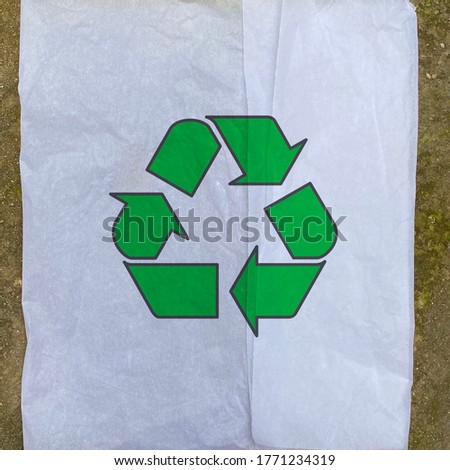Green recycling icon on a tissue paper, reuse daily waste paper materials and reduce pollution, environmental protection background