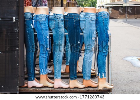 Legs of women mannequins dressed in various jeans in a market outdoors