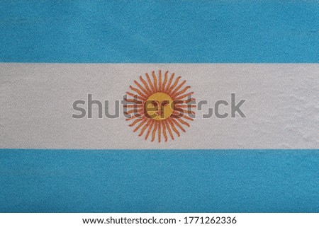 National emblem of Argentina. Flag of Argentina on close up. White and blue flag with sun.