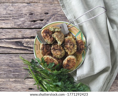 Healthy spring vegetarian and diet food. Vegetable, fish cutlets or chicken cutlets with a plentiful addition of useful greens on a natural wooden background.