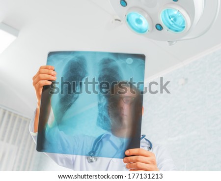Man doctor looks at x-ray image of lungs in a hospital