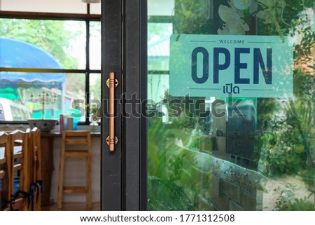 Text Open door sign and hanging up on glass door of coffee shop .