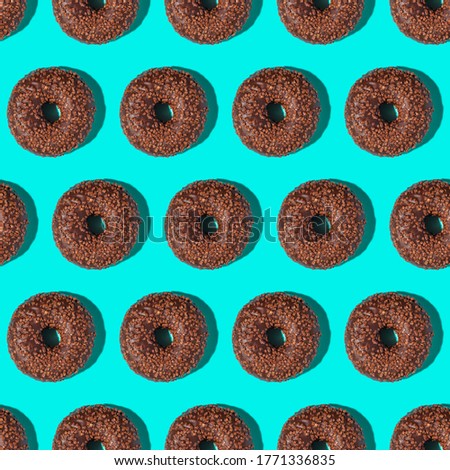 Chocolate brown donuts with sprinkles, sweet glazed dessert seamless pattern on blue background