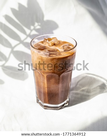 Milk cream iced cold brew coffee. Summer coffee cold drink cocktail with ice and milk. Aesthetic, minimalism. Royalty-Free Stock Photo #1771364912