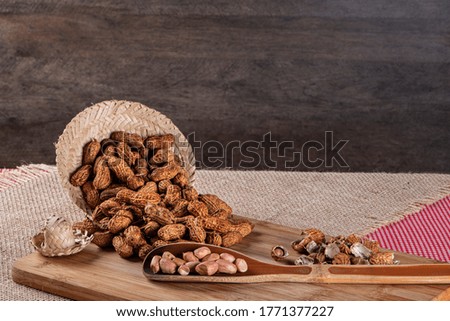 Brazilian june party, typical snack, peanuts, on a checkered cotton tablecloth, on a rustic wooden background.