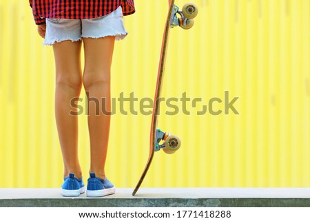 Young skateboarder girl in skate park. Close up view of legs, sneakers, skateboard. Active family lifestyle, outdoor activity on summer holidays in city. Kids sports and teenagers urban fashion.