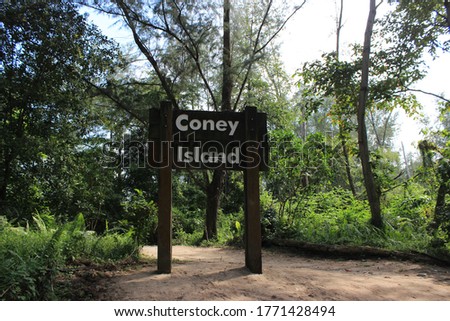 Wooden sign of Coney Island park, forest with a lot of trees in the North of Singapore