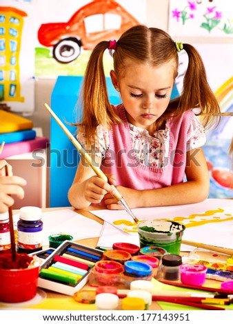 Child painting at easel in school.
