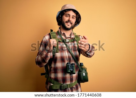 Young hiker man with curly hair and beard hiking wearing backpack and water canteen smiling friendly offering handshake as greeting and welcoming. Successful business. Royalty-Free Stock Photo #1771440608