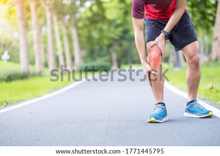 Young adult male with muscle pain during running. runner have knee ache due to Runners Knee or Patellofemoral Pain Syndrome, osteoarthritis and Patellar Tendinitis. Sports injuries and medical concept Royalty-Free Stock Photo #1771445795