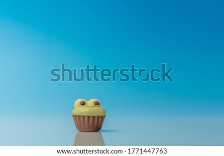 Handmade Belgian chocolate frog, closeup on gradient blue background