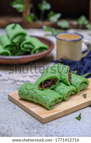 a traditional dessert from Indonesia with blurry baground. it can be classified as a pancake filled with grated coconut mixed with liquid brown sugar. This content is called unti.