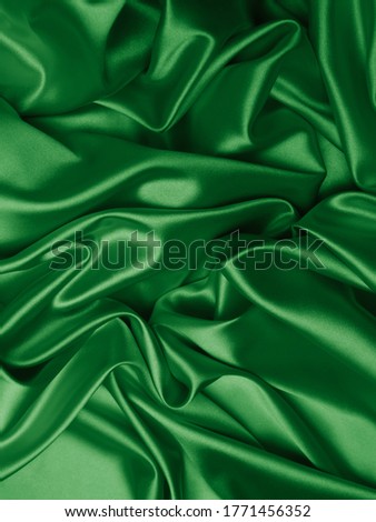 Beautiful smooth elegant wavy green satin silk luxury cloth fabric, abstract background design. Card or banner.