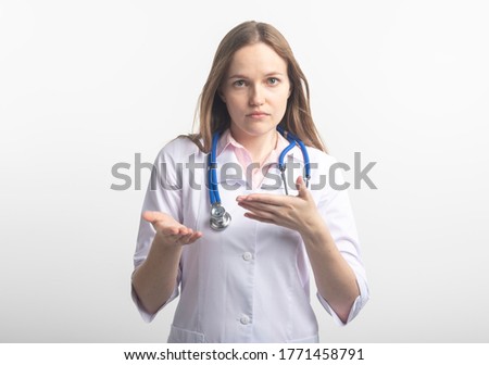 young caucasian female doctor with stethoscope gesturing with hands explaining to camera and looking at camera isolated on white background