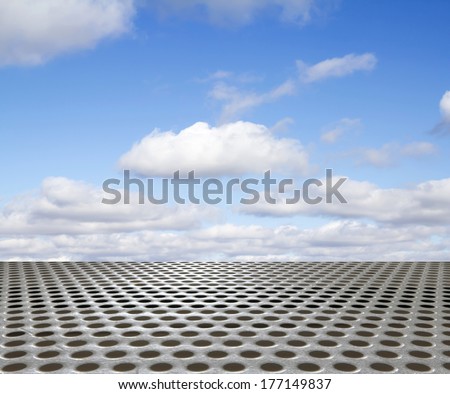 silver metal floor with round hole on the background of blue sky