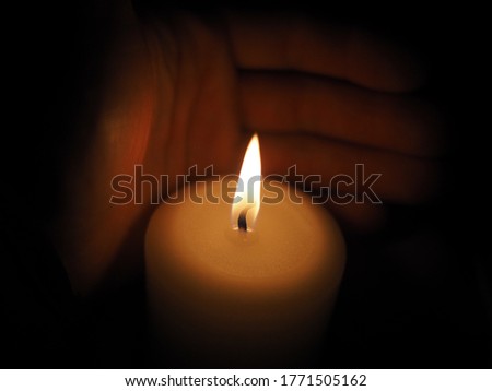 candle in hand on a black background