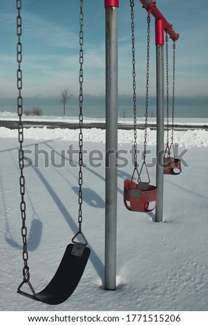 Empty swings in Carol Beach Park in Kenosha, Wisconsin on a snowy day