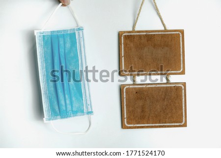 Sanitary mask and wooden sign on a white background