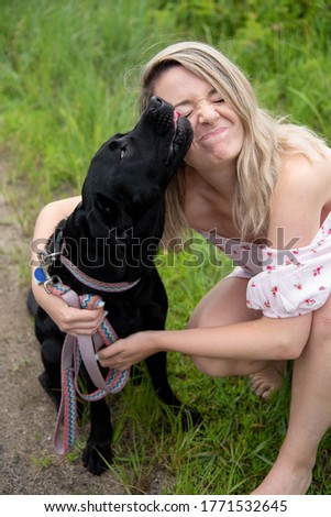 Girl in dress and Black dog on beach