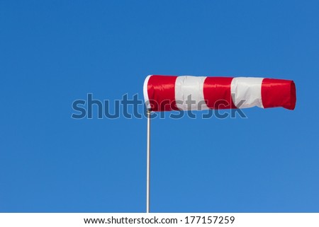 Airfield wind cone at mast, blue sky background