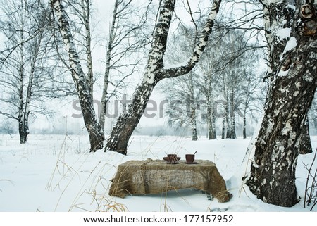 Two cups of tea on background of a winter landscape 