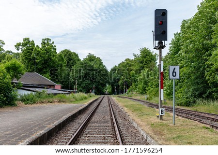 red railway signal at rail track