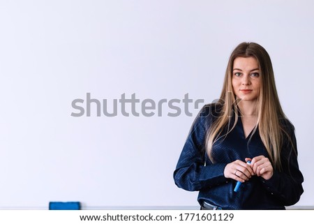 Young teacher at whiteboard holding pen