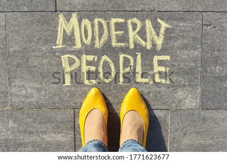 Modern people concept, top view on woman legs and text written in chalk on gray sidewalk.